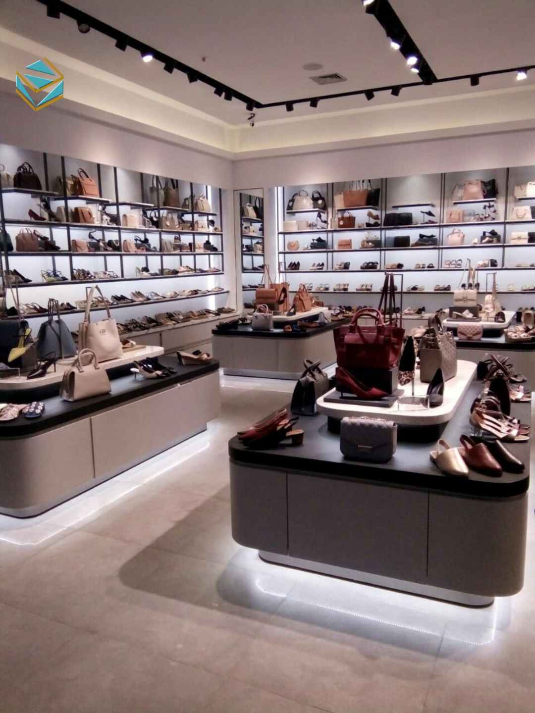 Thi công mặt tiền shop túi xách với kính cường lực, logo thương hiệu rõ ràng và đèn LED viền nổi bật vào ban đêm.