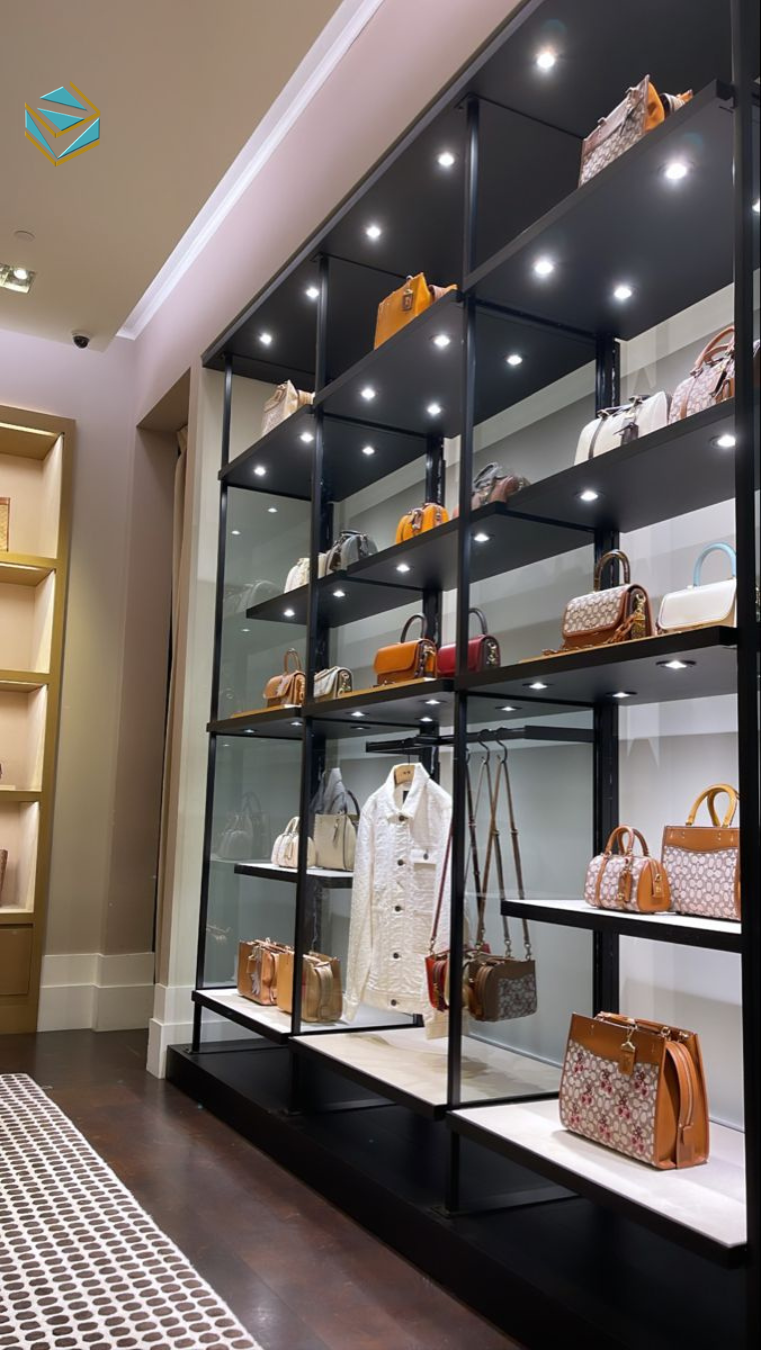 Hệ thống ánh sáng trắng kết hợp vàng ấm giúp nổi bật chất liệu da và màu sắc sản phẩm. Thi công shop túi xách theo xu hướng 2026 ưu tiên hiệu ứng ánh sáng đa tầng.